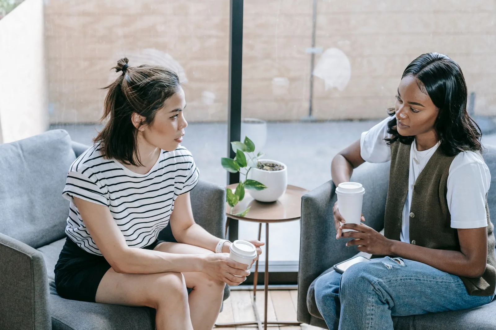 Twee vrouwen in een ontspannen gesprek in een lichte ruimte