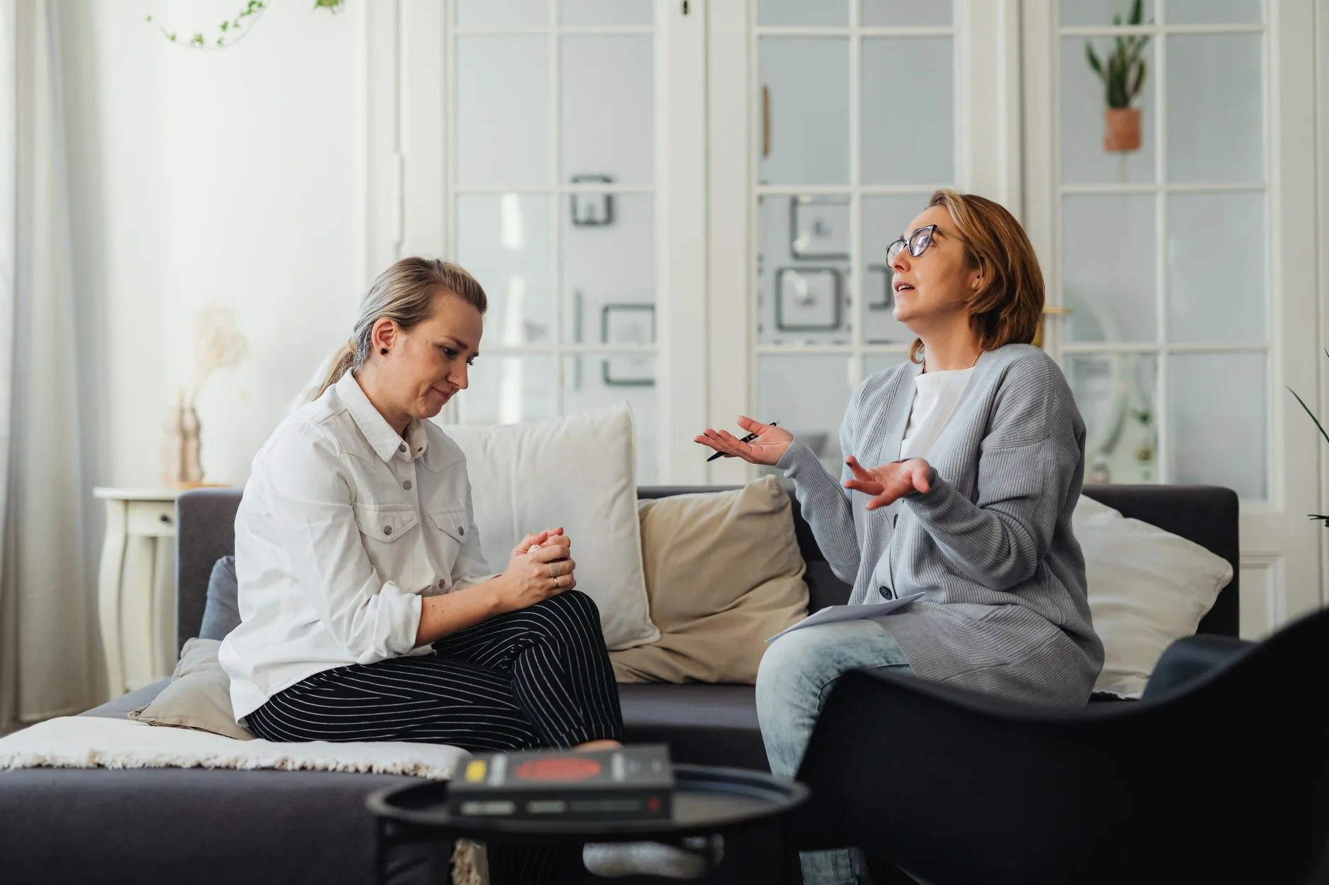 Twee vrouwen in een ontspannen gesprek in een lichte ruimte