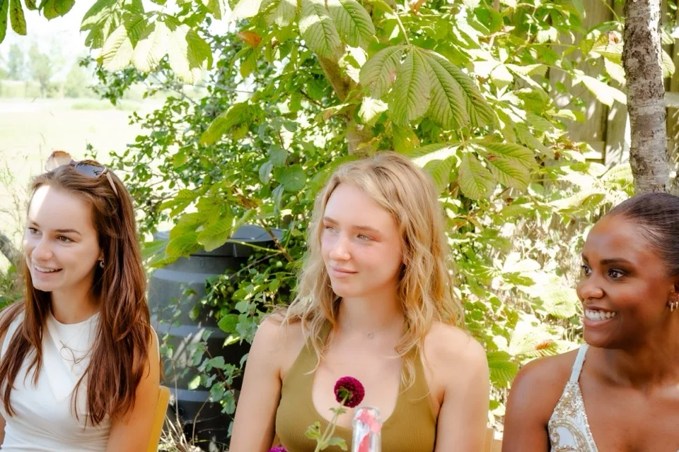Drie vrouwen van de community in gesprek aan de tafel tijdens een event