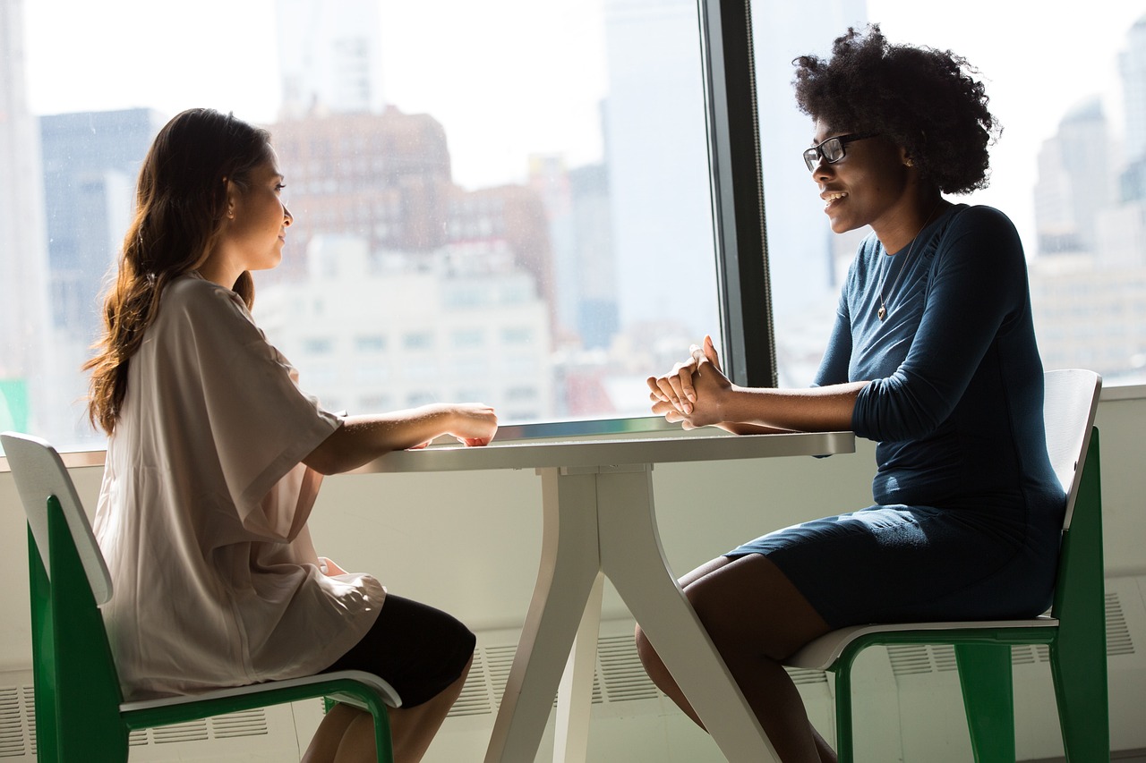 Twee vrouwen bespreken een ondernemersvraag aan tafel